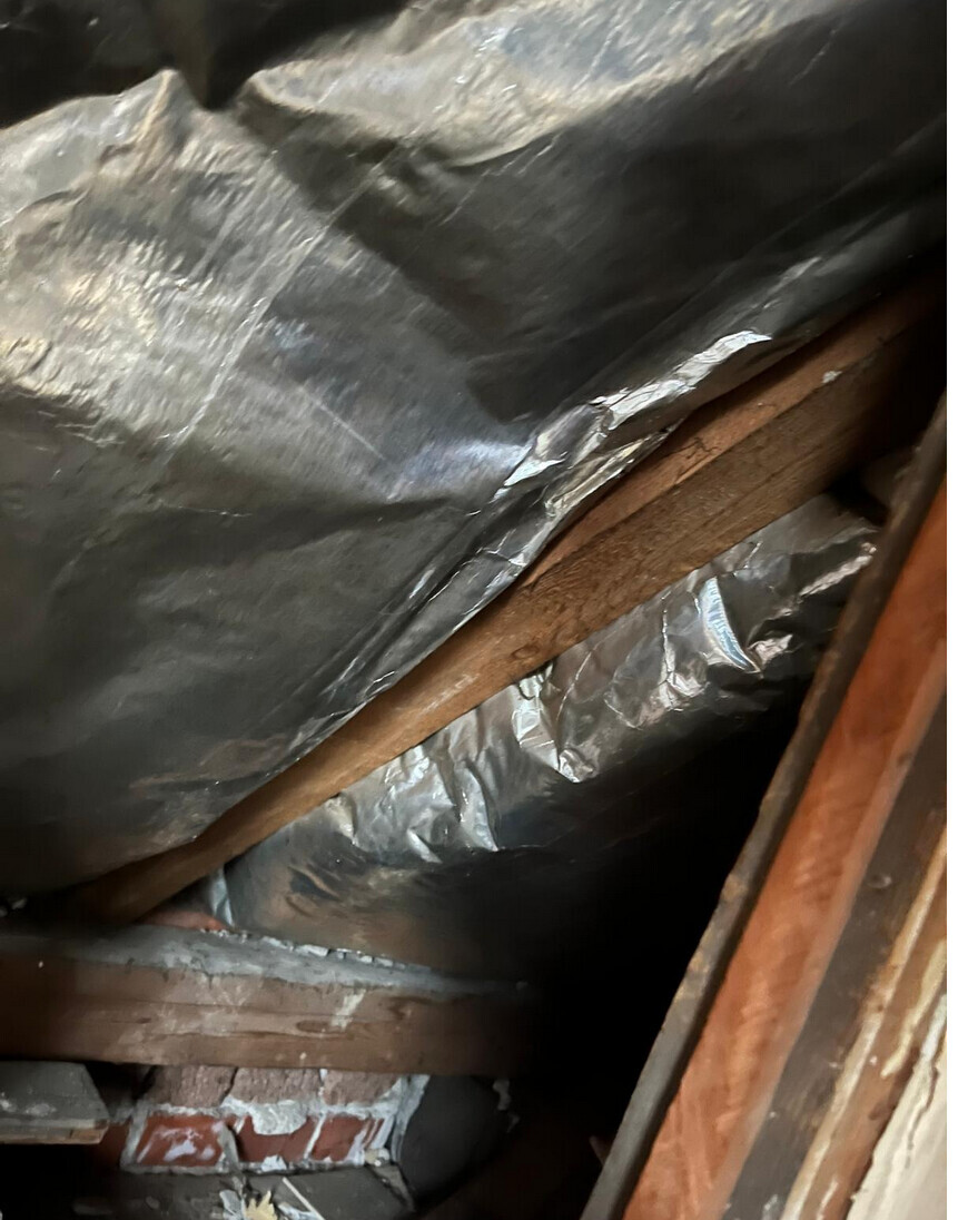 Attic with insulation: aluminum foil insulation and wooden rafters in the roof space