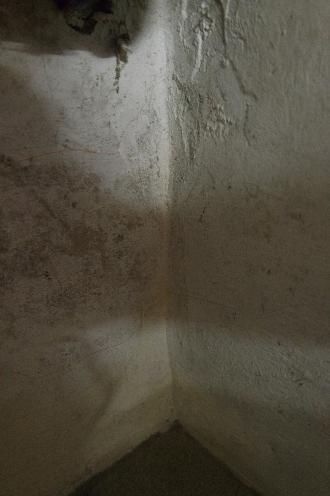 Angular damp basement wall with rough plaster surface and moisture marks