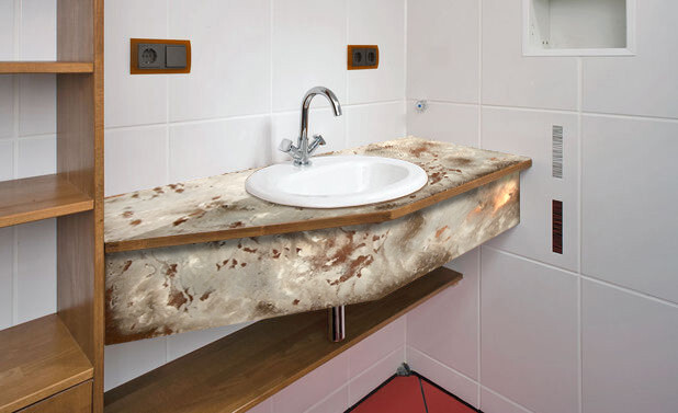 Round sink on a natural stone countertop in front of white wall tiles.