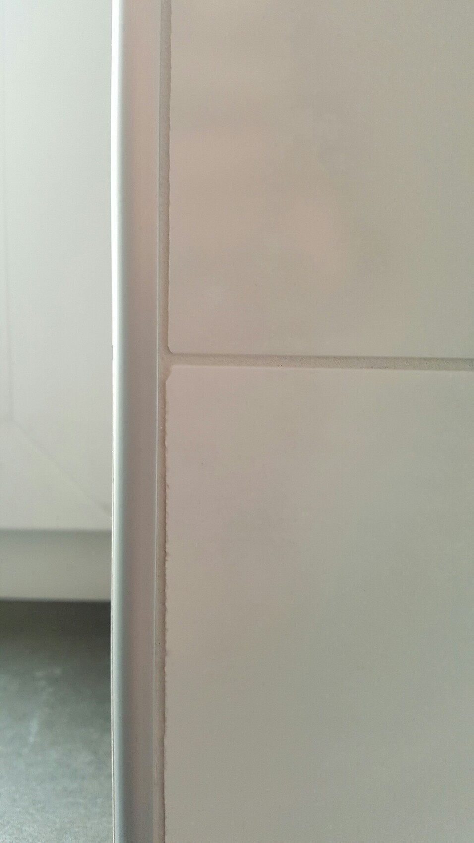 Close-up of a white door frame next to tiles inside the building