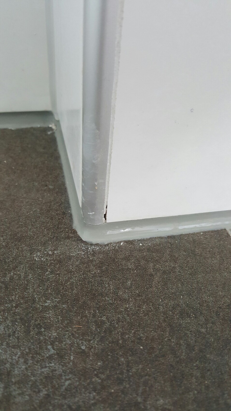 White door frame with gray baseboard on dark floor indoors