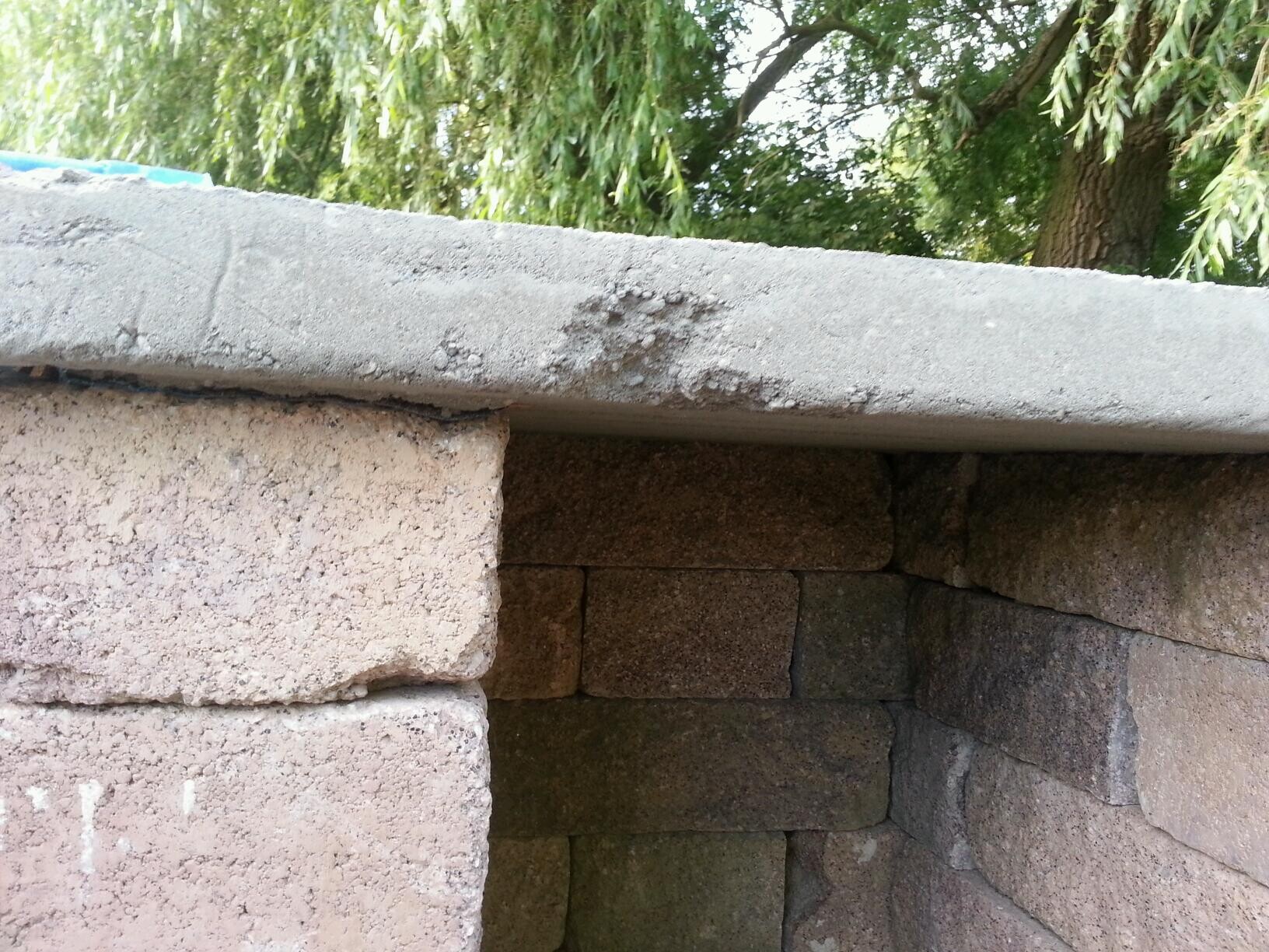 Rohbau aus Steinblöcken mit Betonplatte als Oberseite, offener Fundamentbereich.